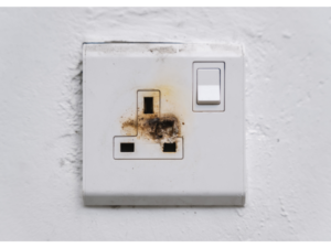 An electrical socket with burn and scorch marks. Signs of needing a home rewire. 